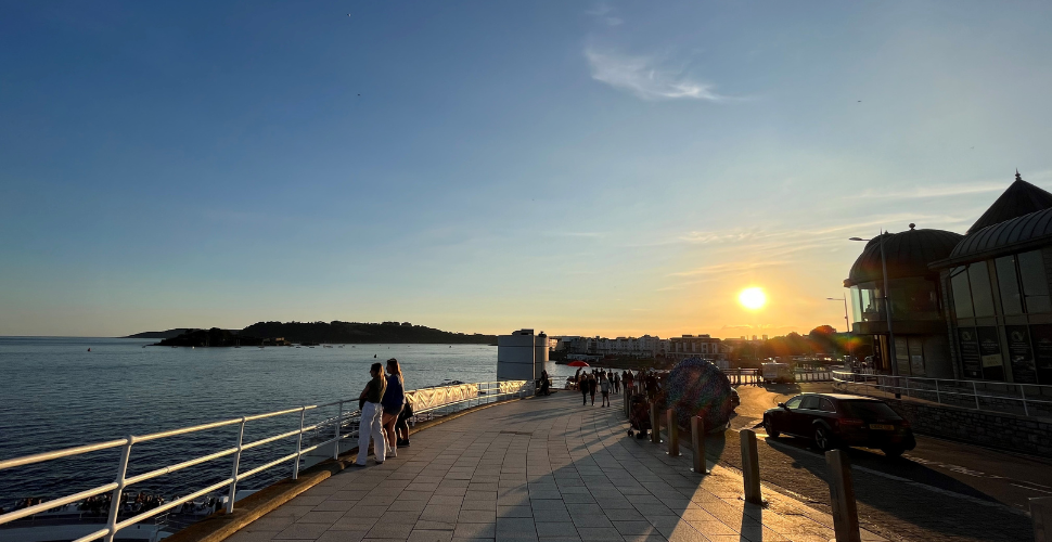 Sunset on Plymouth Hoe with the sea to the left and Ocean View restaurant on the right